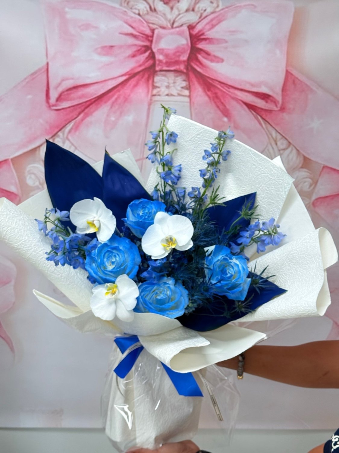 Blue roses and white orchids in a premium wrapped bouquet