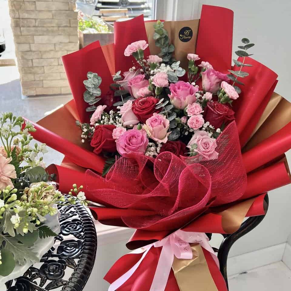 Red and pink rose bouquet with blush ribbon